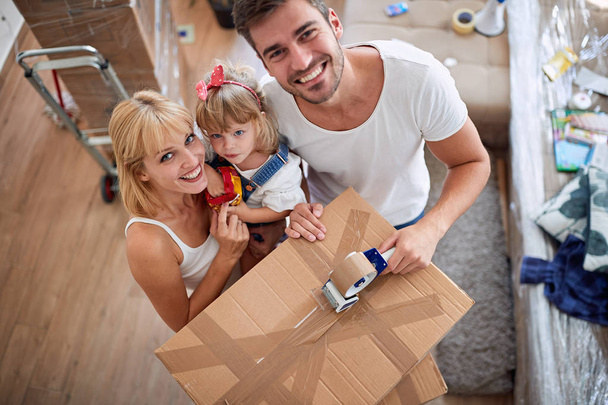 Счастливая семья с картонными коробками в новом доме
 - Фото, изображение