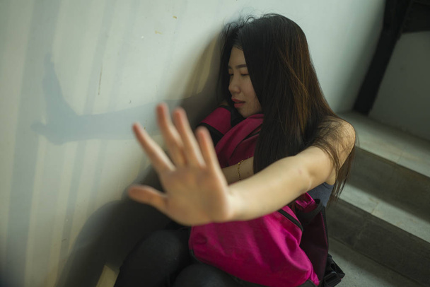 junge schöne depressive asiatische chinesische Studentin sitzt auf dem Campus Treppe Opfer von Missbrauch das Gefühl Angst und einsam belästigt und gemobbt zu werden - Foto, Bild