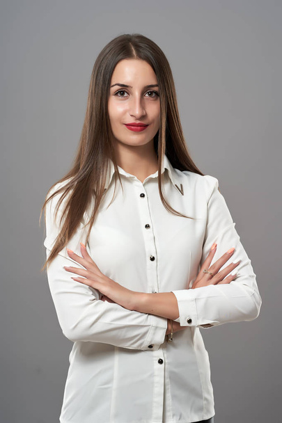 Attractive young Latin businesswoman on gray background - Foto, afbeelding
