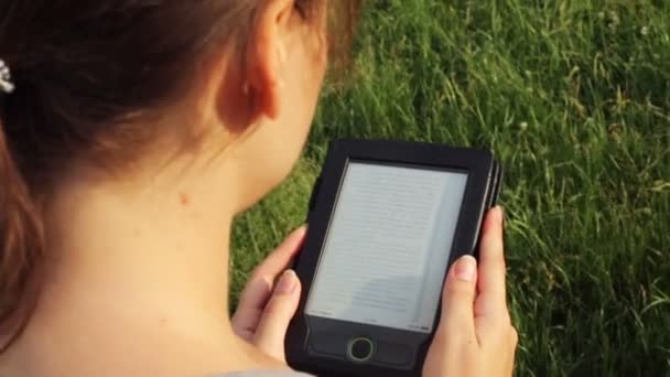 Lány olvasó egy e betű-könyv a természetben - Felvétel, videó
