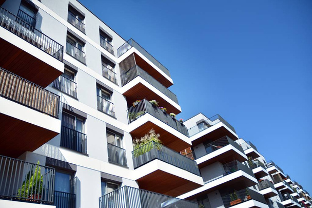 Mavi gökyüzü olan güneşli bir günde modern apartman binaları. Modern bir apartmanın cephesi - Fotoğraf, Görsel