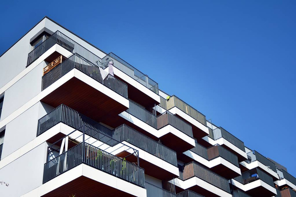 Nykyaikaiset kerrostalot aurinkoisena päivänä sinisellä taivaalla. Modernin kerrostalon julkisivu - Valokuva, kuva