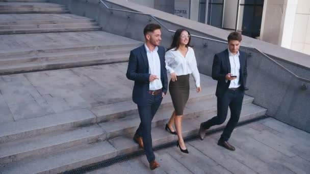 Başarılı İş Adamları İş Tartışmak ve Central Business District yürümek. İki Genç Erkek ve Takım Elbiseli Bir Kadın İletişim ve İş Merkezi Ofis Binası yakınında yürümek. - Video, Çekim