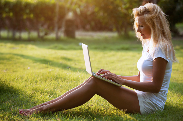 Woman sitting on the grass with the laptop - Zdjęcie, obraz