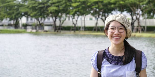 Mignon asiatique femme portant des lunettes souriant dans le jardin
 - Photo, image