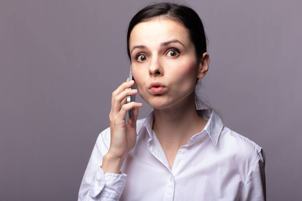 girl in a white shirt  communicates on the phone - Fotó, kép