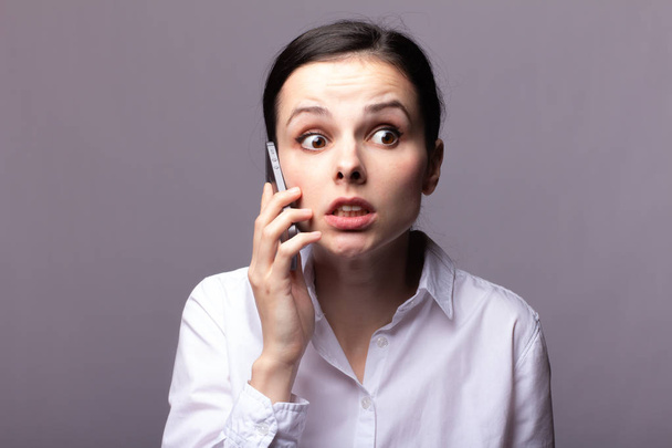girl in a white shirt  communicates on the phone - Foto, Bild