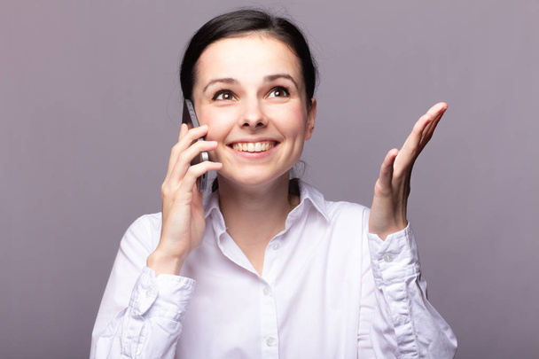 girl in a white shirt  communicates on the phone - Zdjęcie, obraz