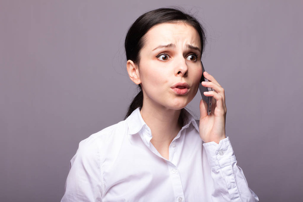 girl in a white shirt  communicates on the phone - 写真・画像