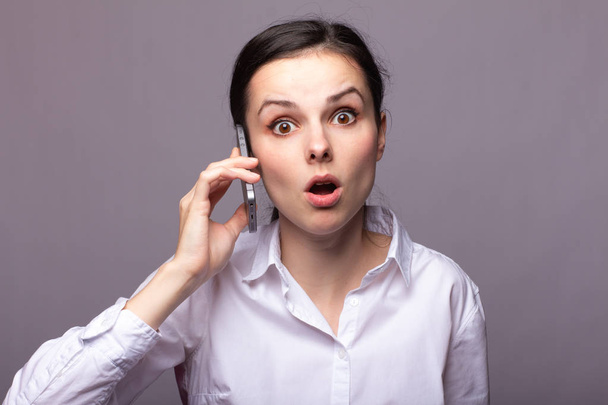 girl in a white shirt communicates on the phone - Zdjęcie, obraz