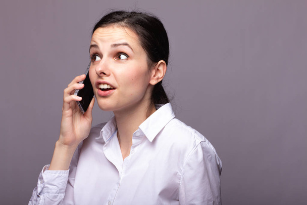 girl in a white shirt communicates on the phone - Foto, Imagem