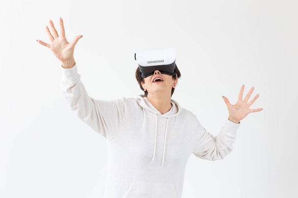 Modern technologies, future and people concept - Woman 40-50 years old wearing virtual reality glasses on white background - Foto, imagen