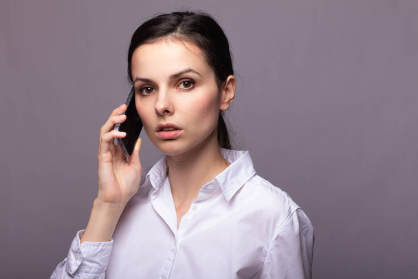 girl in a white shirt communicates on the phone - Foto, Imagen
