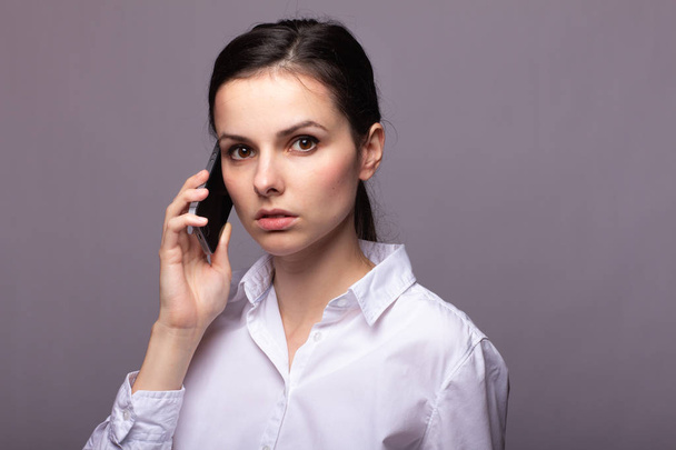 girl in a white shirt communicates on the phone - Foto, Imagen