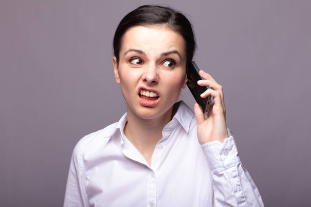 girl in a white shirt communicates on the phone - Φωτογραφία, εικόνα