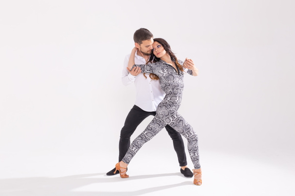 Νεαρό έρωτα ζευγάρι που χορεύει κοινωνική Danse κιζωνμπα ή Μπατσάτα πάνω από το λευκό φόντο με χώρο αντιγραφής - Φωτογραφία, εικόνα