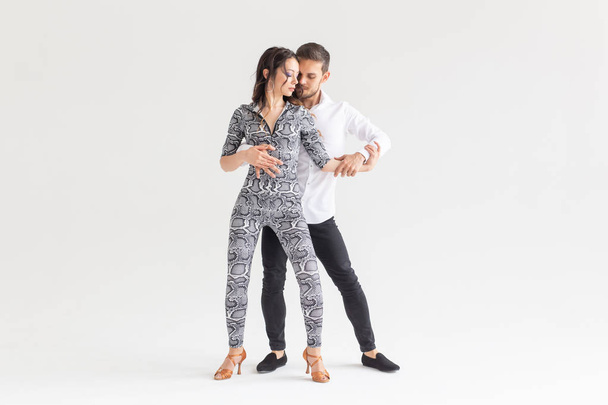 Concepto de danza social - Adultos felices activos bailando bachata juntos sobre fondo blanco con espacio de copia
 - Foto, Imagen