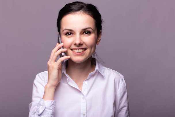 girl in a white shirt communicates on the phone - Fotó, kép