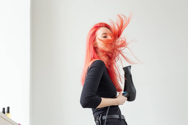 Kampaaja, kauneushoitola ja ihmiset käsite nuori nainen kampaaja hiustenkuivaaja valkoisella pohjalla
 - Valokuva, kuva