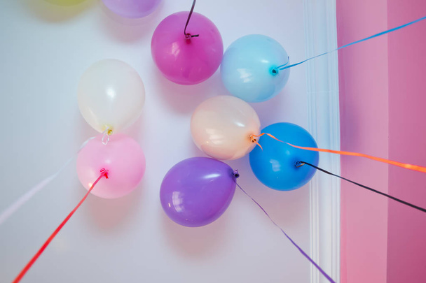 Des ballons colorés flottent sur le plafond blanc dans la pièce pour la fête. Décoration de mariage ou fête d'anniversaire d'enfants intérieur. Ballons d'hélium
 . - Photo, image