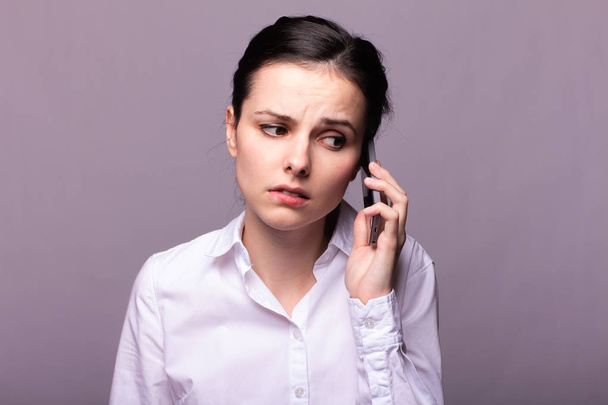 girl in a white shirt communicates on the phone - Fotó, kép