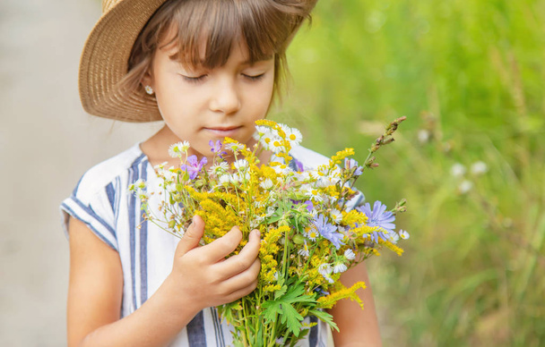 dívku, která drží divoké květiny v rukou dítěte. Selektivní zaměření. - Fotografie, Obrázek