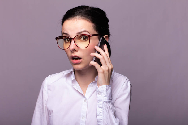 girl in a white shirt and glasses communicates on the phone - Foto, Imagem