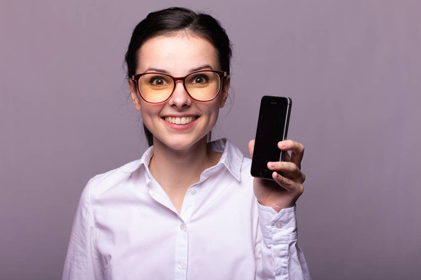 beautiful girl in a white shirt and glasses for vision communicates on the phone - Photo, Image