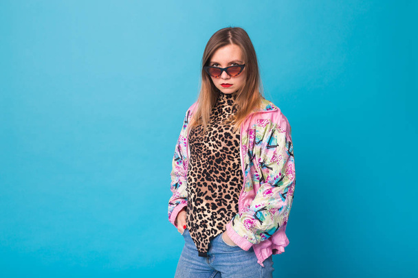 Vintage fashion look concept - pretty young woman wearing a retro pink jacket and leopard body on blue background with copy space - Photo, Image