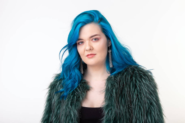 Proteção animal, moda e conceito de cabelo - menina bonita vestida com casaco de pele artificial com cabelo azul em pé sobre fundo branco
 - Foto, Imagem