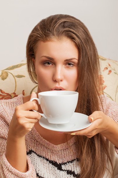 girl blowing on a cup of tea - Фото, зображення
