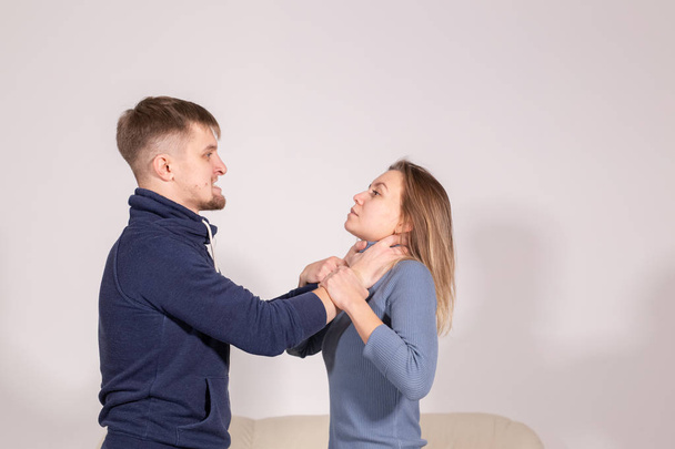 people, domestic violence and abuse concept - young man choked his wife on white background - Photo, Image