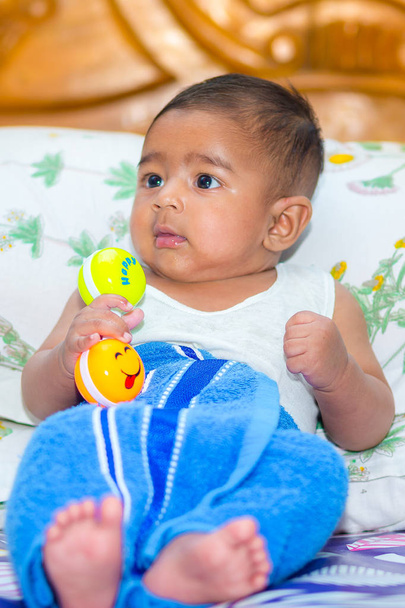 un asiático bebé chico es buscando y jugando en colorido juguetes
. - Foto, Imagen