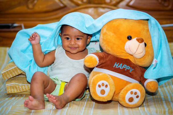 Шість місяців азіатський хлопчик, який грає жовтого пухнастого ведмедя
. - Фото, зображення