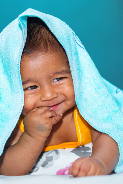 Un niño asiático de seis meses de edad se ríe y bromea bajo el
 - Foto, Imagen