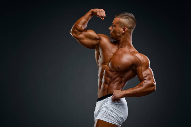 Mladí hezcí svalnatý muž Flexující svaly - Fotografie, Obrázek