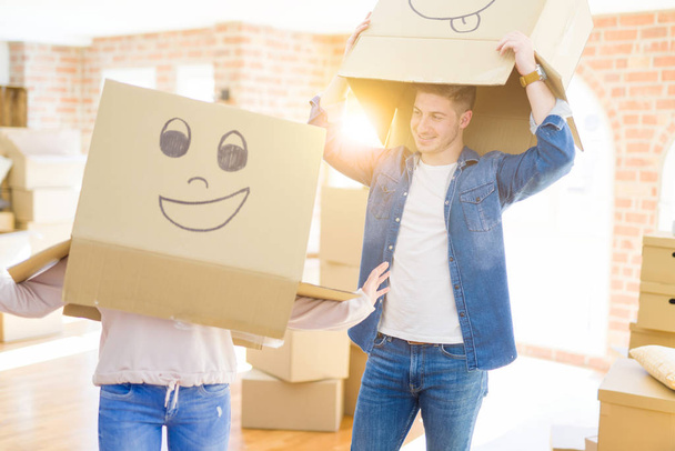 Couple s'amuser dans un nouvel appartement portant des boîtes avec des visages drôles sur la tête
 - Photo, image