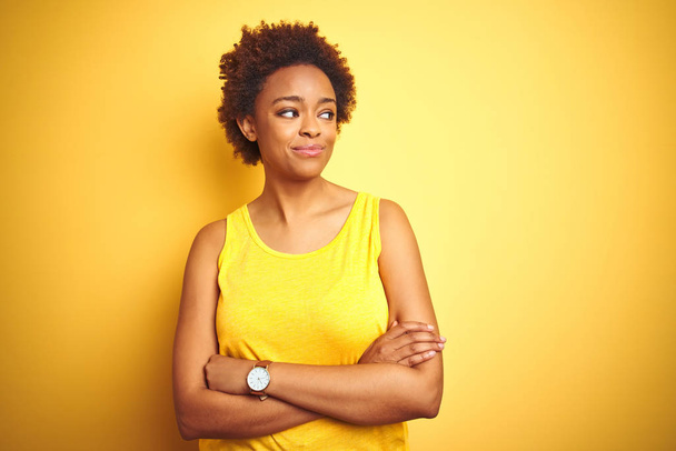 Beauitul Africano americano mulher vestindo verão t-shirt sobre isolado fundo amarelo sorrindo olhando para o lado e olhando para longe pensando
. - Foto, Imagem