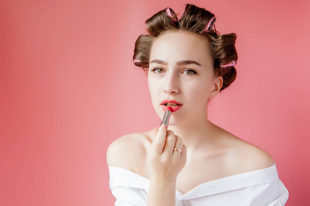 Closeup portrait of beautiful girl putting on red lipstick - Foto, immagini