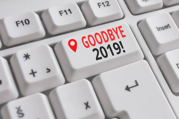 Handwriting text Goodbye 2019. Concept meaning express good wishes when parting or at the end of last year White pc keyboard with empty note paper above white background key copy space. - Photo, Image