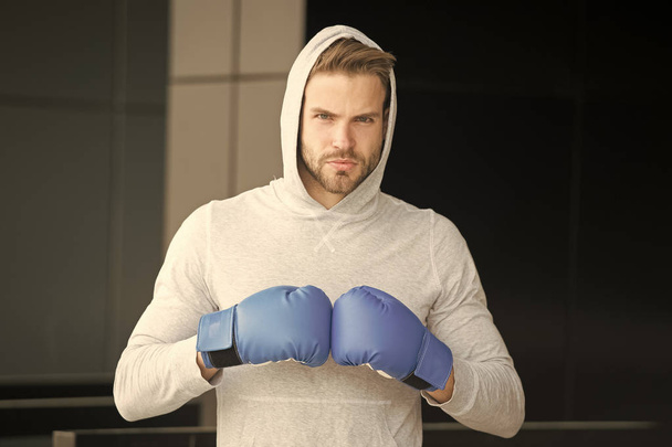 Focused sport goal achievement. Sportsman concentrated training boxing gloves. Athlete concentrated face sport gloves practice fighting skills urban background. Boxer handsome strict coach boxing - Foto, Bild
