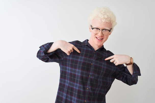 Nuori albiino vaalea mies yllään rento paita ja lasit yli eristetty valkoinen tausta näyttää luottavainen hymyillen kasvot, osoittaa itseään sormilla ylpeä ja onnellinen
. - Valokuva, kuva