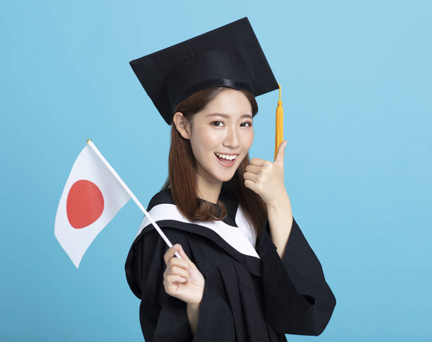 Ευτυχισμένος Ασιάτης/ισσα φοιτήτρια απόφοιτος που δείχνει την Ιαπωνία σημαία - Φωτογραφία, εικόνα