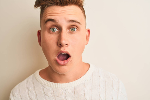 Young handsome man wearing casual t-shirt standing over isolated white background scared in shock with a surprise face, afraid and excited with fear expression - Fotografie, Obrázek