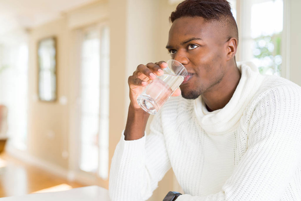 Joven afroamericano bebiendo un vaso de agua fresca
 - Foto, imagen