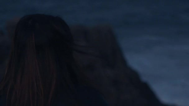 Concept: Sad women starring out into the ocean as the waves crash against the cliffs. - Footage, Video