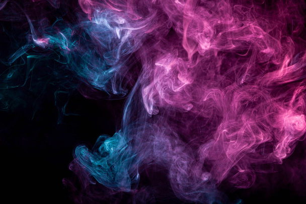 Fumo di motivo rosa e blu su uno sfondo scuro isolato. Simbolo spaventoso e misterioso
 - Foto, immagini