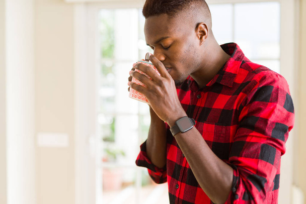 Joven afroamericano bebiendo una taza de café
 - Foto, imagen