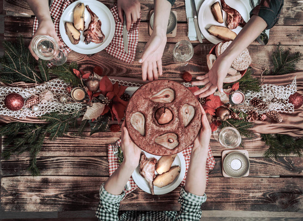 Flat-lay of friends hands eating and drinking together. Top view of people having party, gathering, celebrating together at wooden rustic table - Foto, Bild