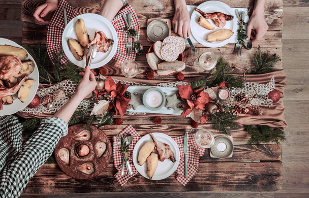 Flat-lay of friends hands eating and drinking together. Top view of people having party, gathering, celebrating together at wooden rustic table - Photo, Image
